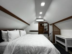 ein Schlafzimmer mit einem großen weißen Bett in einem Zimmer in der Unterkunft Old Klang Road Homestay Dungun in Dungun