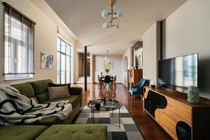 Una sala de estar con un sofá verde y un televisor. en Boho Lofts - LoftAffair, en Cracovia
