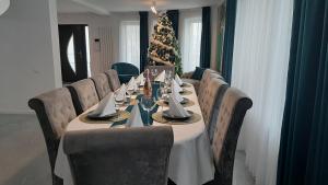 a long table with chairs and a christmas tree at Casa Evelin in Turda