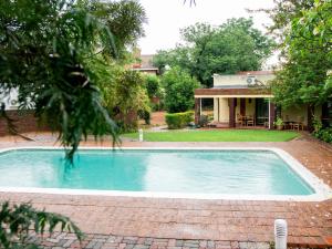 a swimming pool in the yard of a house at River-Ridge Guest House in Gaborone