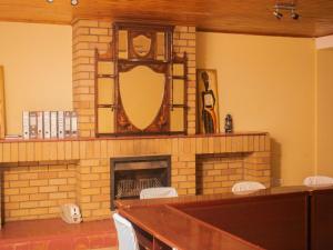 a room with a fireplace with a mirror and chairs at River-Ridge Guest House in Gaborone
