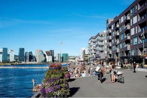 un grupo de personas en una playa cerca del agua en Seafront Apartment at Sørengka OSLO, en Oslo