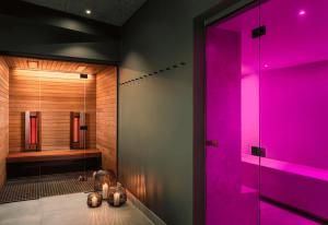 baño con iluminación rosa y ducha en FAVORITE Parkhotel, en Mainz
