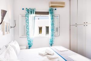 um quarto branco com cortinas azuis e uma cama em Garden Apartments em Rózia