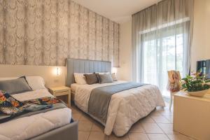 - une chambre avec 2 lits et une fenêtre dans l'établissement Hotel Athena, à Cervia