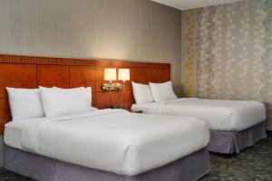 two beds in a hotel room with white pillows at Courtyard by Marriott Akron Stow in Stow