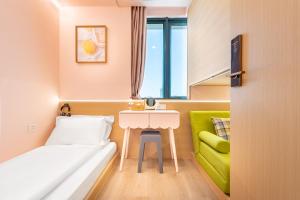 a small room with a bed and a table at Lemon Hotel - Metro Line 1 Line 7 Changshu Road 200 meters in Shanghai