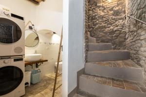 a bathroom with a stone wall and stairs next to a washing machine at Casa Vesta in San Gimignano