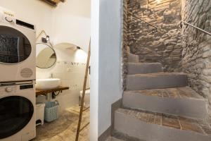 een badkamer met een stenen muur en een trap naast een wasmachine bij Casa Vesta in San Gimignano