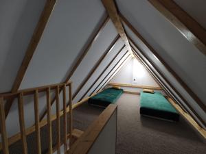 an attic room with two green beds in it at Dwie Chatki domek in Sandomierz