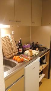 a kitchen with a sink and a counter with food and bottles at Découverte de la vallée d'Eyne et des bains de Llo in Eyne