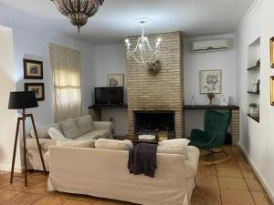 a living room with a couch and a fireplace at Casa Rural Los Menestrales in Lora del Río