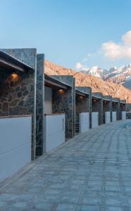 a row of garage doors on a building with mountains in the background at Himmel Skardu By Luxus in Skardu