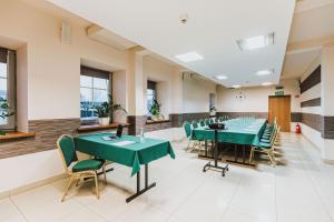 uma sala de conferências com mesas e cadeiras verdes em Hotel Gromada Radom Centrum em Radom