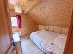 a bedroom with a bed in a wooden cabin at Le chalet des Broches - jacuzzi in Xonrupt-Longemer