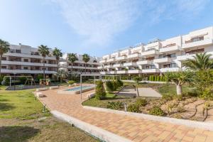 a large apartment building with a playground in front of it at Terrazas de Campoamor Sunrise in Orihuela