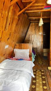 sypialnia z łóżkiem w drewnianym pokoju w obiekcie JOYstels Manali w mieście Manāli