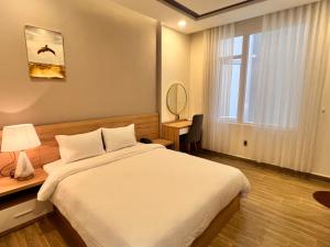 - une chambre avec un lit, un bureau et une fenêtre dans l'établissement Q's House Dalat, à Đà Lạt