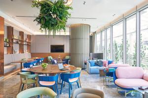 a lobby with a table and chairs and a room with windows at Capri by Fraser China Square, Singapore in Singapore