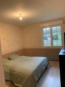 a bedroom with a bed and a window at Maison de campagne proche de Sézanne avec parking in Le Meix-Saint-Époing