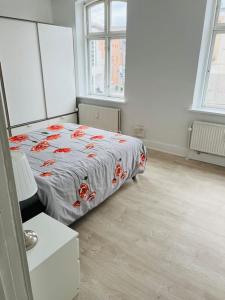 a bedroom with a bed in a room with windows at Lovely 1-bedroom condo in Aarhus C in Aarhus