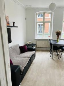 ein Wohnzimmer mit einem Sofa und einem Tisch in der Unterkunft Lovely 1-bedroom condo in Aarhus C in Arhus