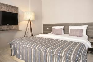 a bedroom with a large bed with a tv on the wall at The Breeze Hotel in Eskisehir