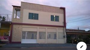un bâtiment avec deux portes de garage sur son côté dans l'établissement Casa confortável e bem localizada, à Macapá