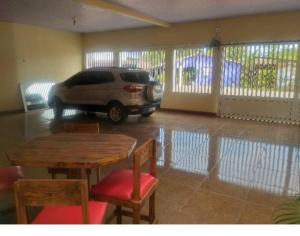 Casa confortável e bem localizada في ماكابا: سيارة متوقفة في كراج مع طاولة وكراسي