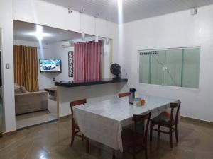 Casa confortável e bem localizada في ماكابا: غرفة طعام وغرفة معيشة مع طاولة وكراسي
