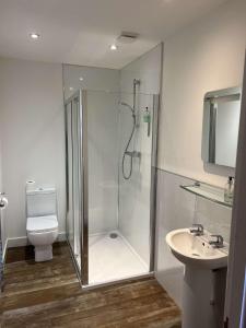 a bathroom with a shower and a toilet and a sink at Crown Hotel & Bar in Inverness