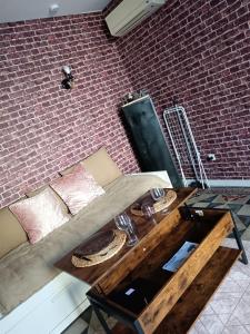uma sala de estar com uma mesa e uma parede de tijolos em Studio maillane em Maillane