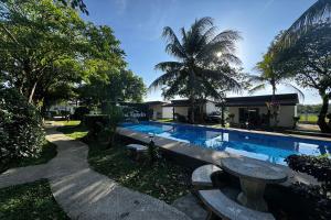 a swimming pool with a bench next to a house at Ozone Resort & Pool Villa in Phatthalung
