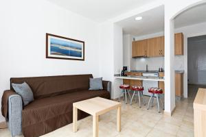 卡门港Guasimeta Duplex - Pool & Balcony的客厅里有一张沙发和一个厨房
