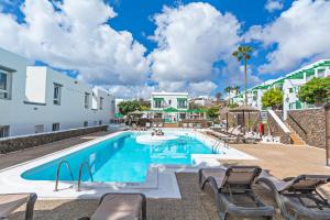卡门港Guasimeta Duplex - Pool & Balcony的建筑物旁边有带躺椅的游泳池
