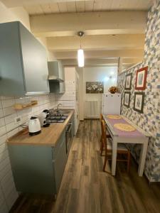 una cocina con encimera y mesa con estufa en DOMUS TUSCIA APARTMENTS Via Piana 1, en Viterbo