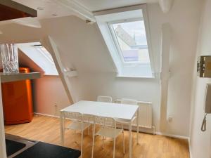 奧胡斯的住宿－Lovely 1 room Apartment Aarhus C，一间配备有白色桌椅的用餐室