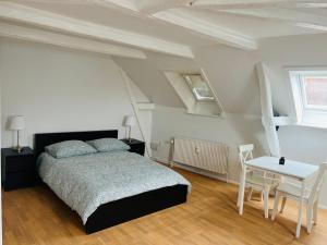 Un dormitorio con una cama y una mesa. en Lovely 1 room Apartment Aarhus C, en Aarhus