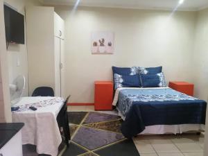 Zimmer mit 2 Betten und einem Tisch in der Unterkunft Limelight in Polokwane