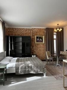 a bedroom with a bed and a brick wall at Gosudar Hotel in Kropyvnytskyi