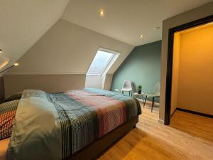 een slaapkamer op zolder met een bed en een raam bij De Lindehoeve Appelscha in Appelscha