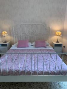 レッチェにあるLuna Piena B&Bのピンクの枕とランプ2つ(テーブル2つ)が備わるベッド1台