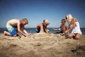 un grupo de personas jugando en la arena en la playa en Dog Friendly Caravan Near To Heacham Beach, Ref 21011c, en Heacham