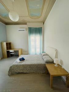 a bedroom with a bed and a table and a window at Deodato Guest House in Catania