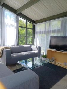 a living room with two couches and a flat screen tv at Hemma fran Hemma - Stuga in Kvillsfors