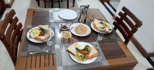 una mesa de madera con platos de comida. en White Block Hotel & Resturant en Hatton