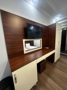 Habitación con escritorio y TV en la pared. en Ada apart motel, en Marmara