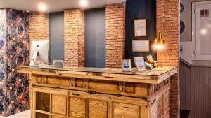 a wooden counter in a room with brick walls at Santa Rita Rita B&Boutique in Talavera de la Reina