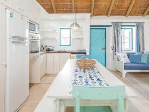 una cocina con una mesa con una cesta. en Zandtorini Seaside Cottage, en Struisbaai