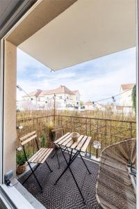 d'une terrasse avec une table et des chaises sur un balcon. dans l'établissement Appartement Proche Disney Paris Vidéo-Projecteur, à Bussy-Saint-Georges